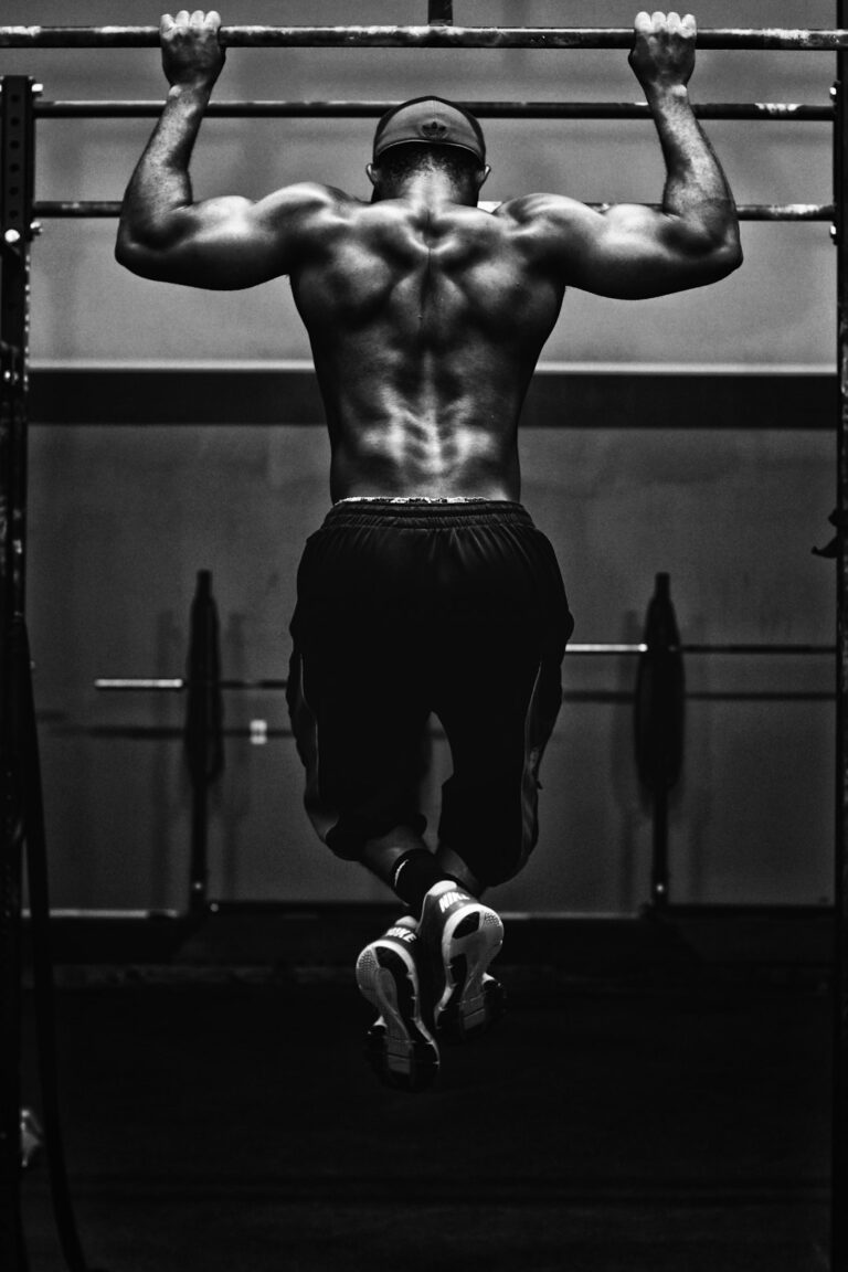 Adults performing controlled resistance exercises with free weights in a bright, well-ventilated gym.